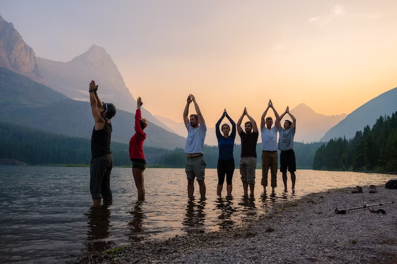 group of people standing in the lake and doing meditation